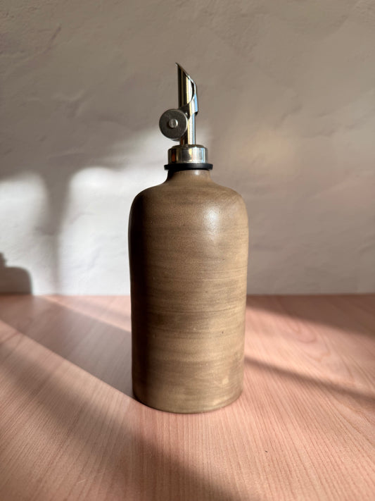Handmade ceramic olive oil bottle in a matte olive-brown glaze with steel spout