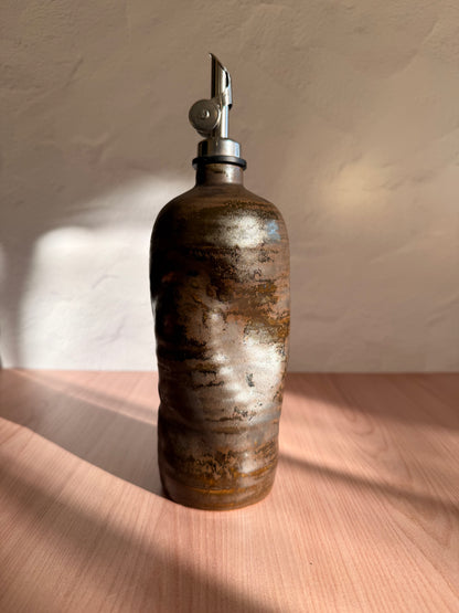 Handmade ceramic olive oil bottle in a streaked bronze glaze with steel spout