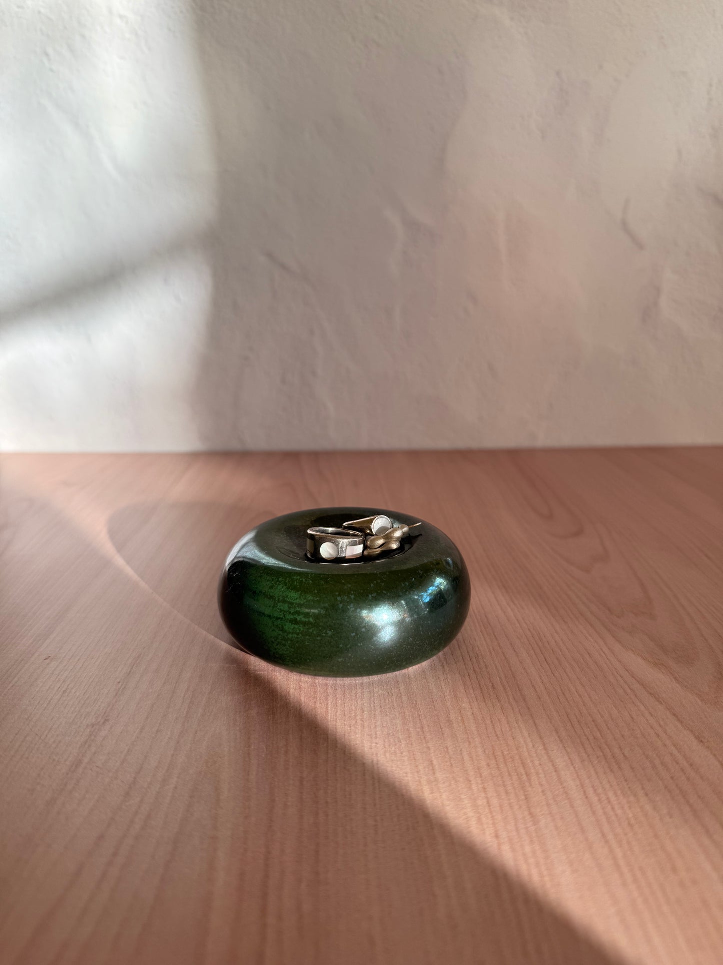 Round handmade ceramic catch-all dish with glossy forest green glaze