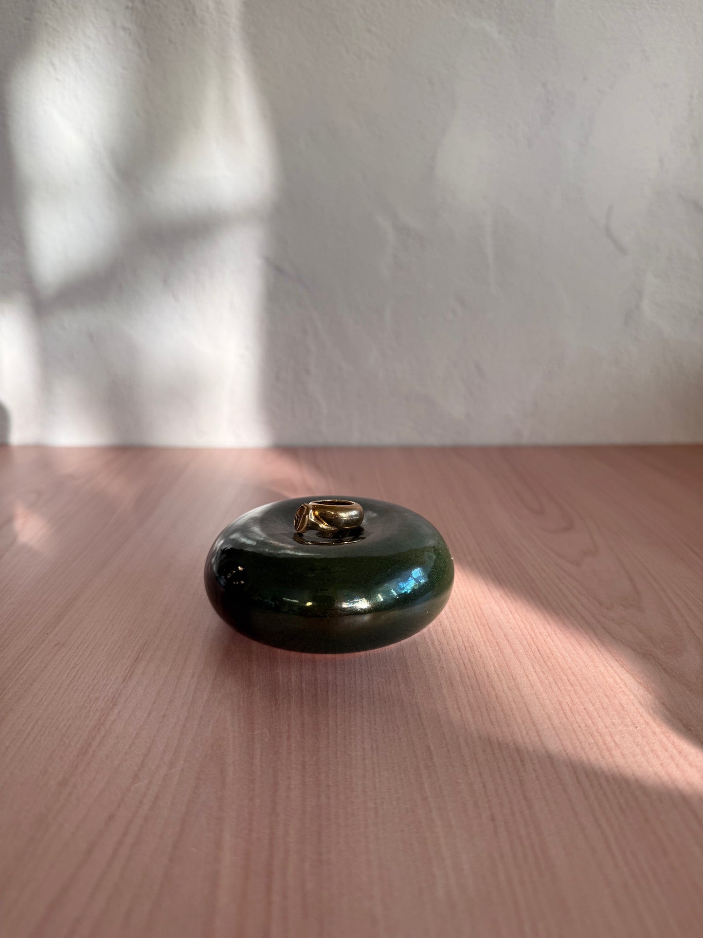 Round handmade ceramic catch-all dish with glossy deep green glaze