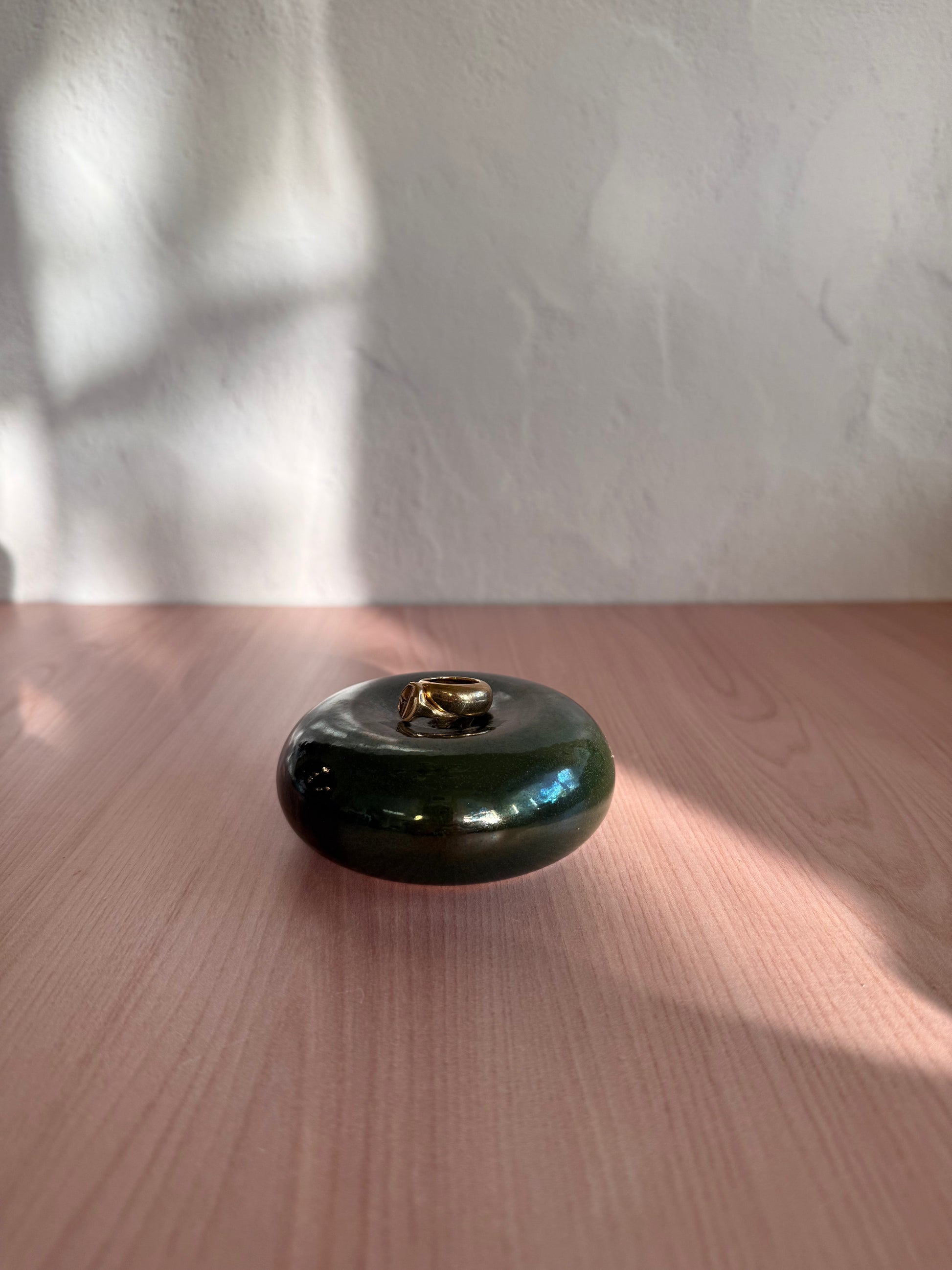 Round handmade ceramic catch-all dish with glossy deep green glaze