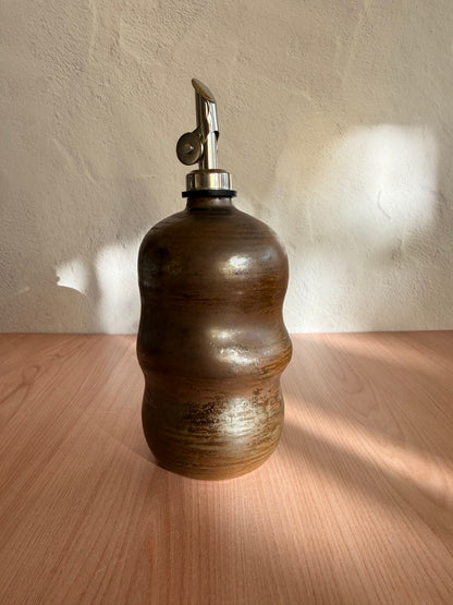 Handmade ceramic olive oil bottle with sculptural shape and bronze glaze