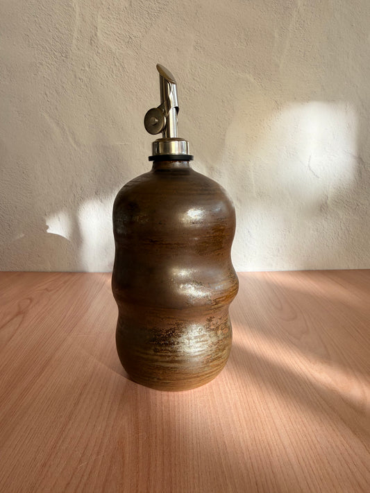 Handmade ceramic olive oil bottle with sculptural shape and bronze glaze