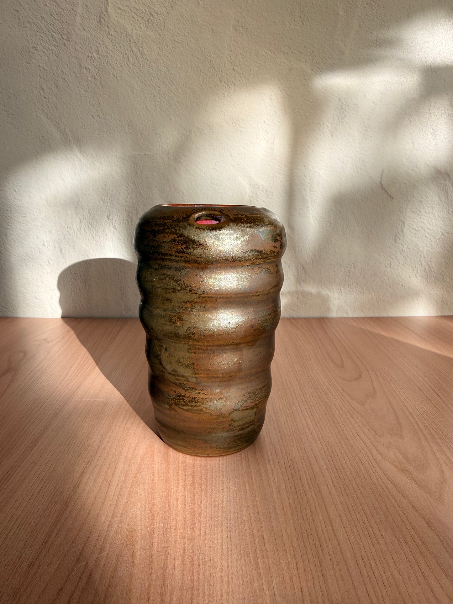 Handmade ceramic travel mug with ribbed texture and bronze glaze